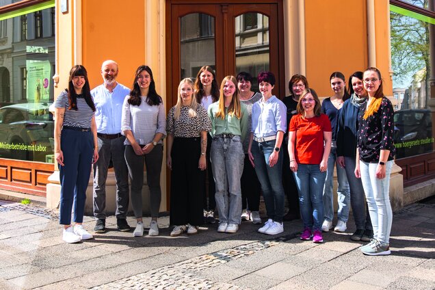 Gruppenbild aller Mitarbeiter von Hörgeräte Jens Steudler, die vor einer Filiale stehen
